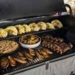 traeger grill open in winter, laden with grilled food